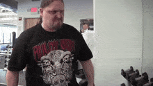 a man wearing a shirt that says billy dooy is standing in a gym