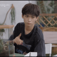 a young man wearing a black shirt that says ' aoolala ' on it