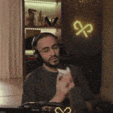 a man wearing headphones is sitting in front of a microphone in a room .
