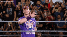 a wrestler wears a purple shirt that says time is now
