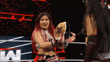 a woman in a wrestling ring holding a championship belt that says ' pro ' on it