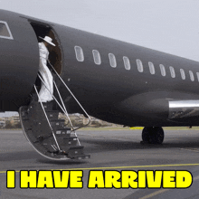 a black airplane with the words " i have arrived " on the bottom