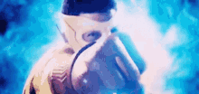 a man in a mask is standing in front of a blue background and smoke .
