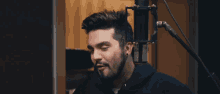 a man singing into a microphone with a beard