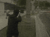 a man in a black jacket walking down a street with a fire hydrant in the background