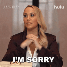 a woman says i 'm sorry in front of an ad for hulu