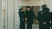 a group of boys are standing in a hallway and one of them is holding a yellow can