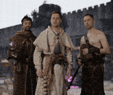 three men dressed in medieval costumes standing next to each other