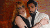 a man and a woman are standing next to each other and the woman has a black eye