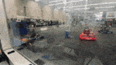 a group of robots are racing in a building with a sign that says first