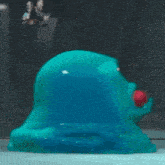 a cartoon character is looking at a blue blob with red eyes