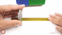 a person is playing with magnetic beads and the words made in animatica can be seen on the bottom
