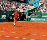 a tennis player is running on a court with an ad for bnp paribas behind him