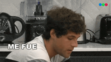 a man sitting in front of a blender and a toaster that says me fue on it