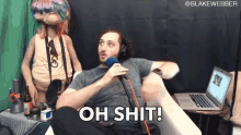 a man sitting in front of a microphone with the words oh shit below him