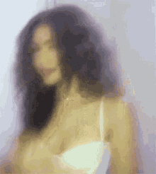 a blurry photo of a woman in a white bra .