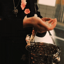 a person holding a bucket with a chain around the handle