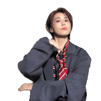 a woman in a suit and tie has her arm up
