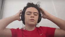 a young man wearing headphones and a red shirt that says ' i love you '