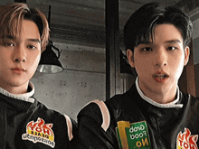 two boys wearing black jackets with a green patch that says dane boo7 on it