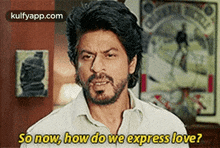 a man with a beard is standing in front of a clock and says `` so now , how do we express love ? ''