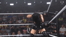 a woman is in a wrestling ring with a w logo on the side