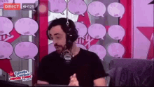 a man wearing headphones is talking into a microphone in front of speech bubbles on a screen .