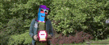 a pixelated image of a man with a purple hat holding a pink box with the number 1 on it