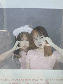 a picture of two girls behind a glass with qr in the corner