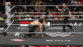 two women are wrestling in a wrestling ring with netflix written on the floor