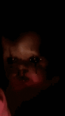 a close up of a clown 's face with blood coming out of it 's eyes .