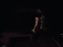a blurred image of a man standing on a stage with a drum set in the background