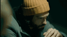 a man with a beard is wearing a yellow hat