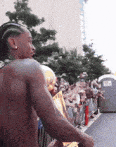 a shirtless man stands in front of a crowd of people
