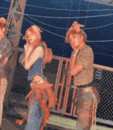 a man and a woman are standing next to each other on a fence