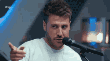 a man in front of a microphone with rtve written on the bottom