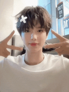a person with a bandage on their head giving the peace sign