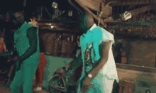 two men are dancing in front of a crowd of people in a dark room .