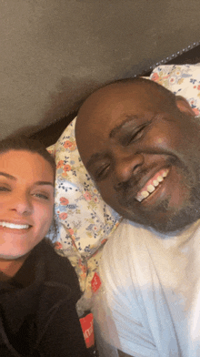 a man and a woman are posing for a picture while laying in bed