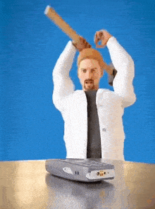 a man in a white coat is holding a wooden bat over a cell phone