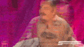 a man with a mustache is making a funny face in front of a pink background with the word thinkiules on it