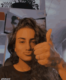 a woman giving a thumbs up with gifsdayrol written on the bottom right