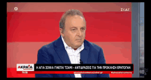 a man in a suit is talking on a tv channel