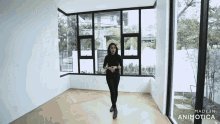 a woman standing in an empty room with the words made in animotica on the bottom right