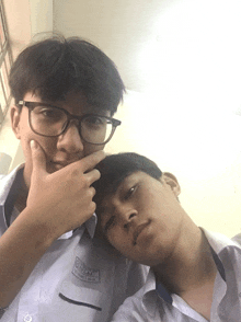 two boys are posing for a picture with one wearing a shirt that says " trung " on it