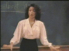 a woman is standing in front of a blackboard with the word albert on it