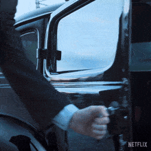a man in a suit opens the door of a car with netflix written on the bottom right