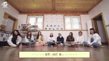 a group of girls sit on the floor in front of a sign that says twice on it