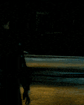 a man in a superman costume is standing in a dark room