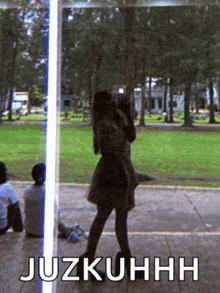 a woman is taking a picture of herself in a park with the words juzkuhhh written below her